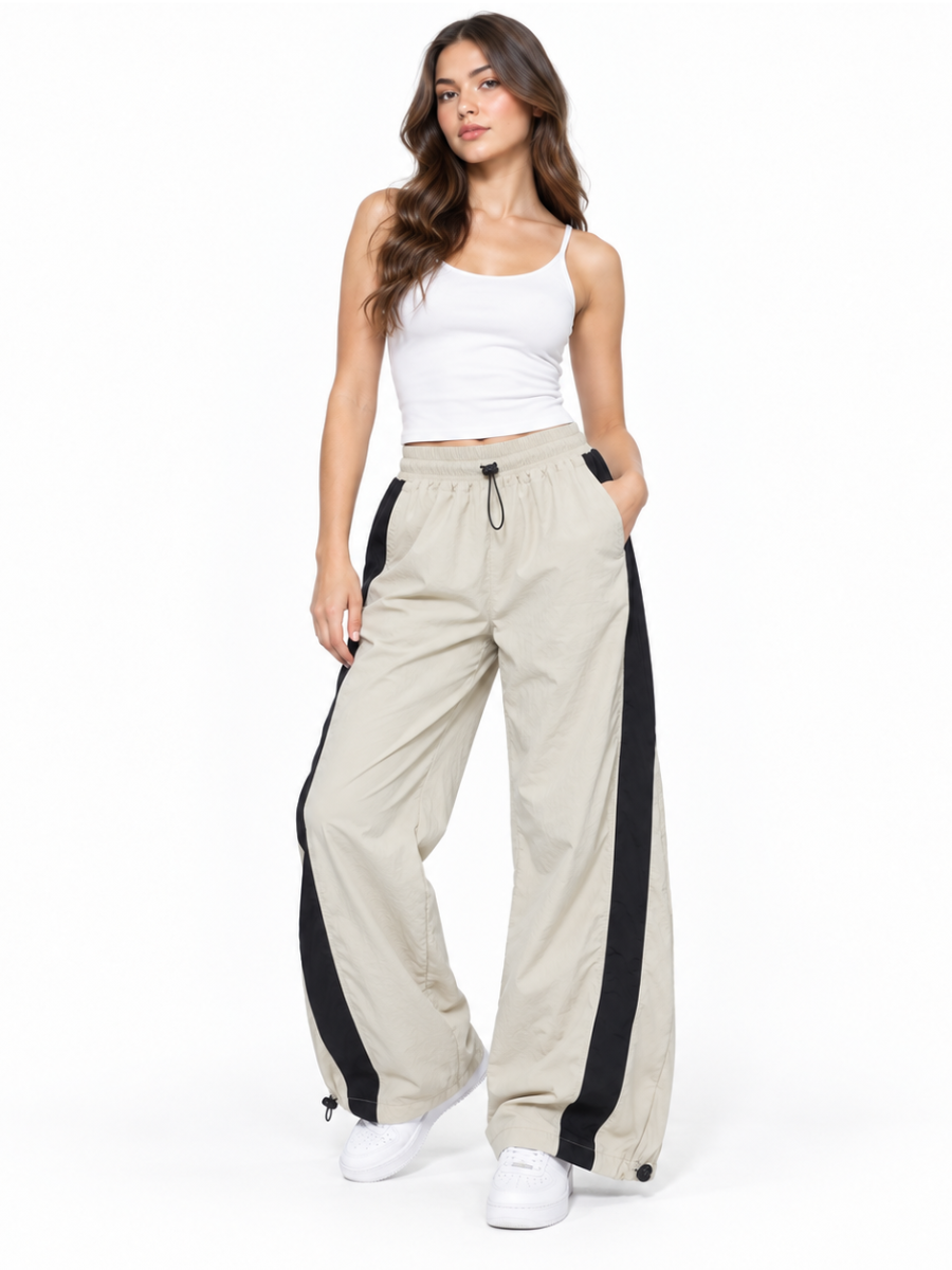 Mujer con pantalón Aura Oversized de tela mojada color hueso y franjas negras laterales